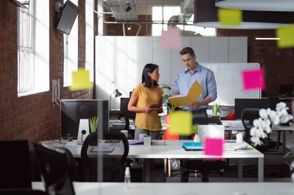 Caucasian-male-and-female-colleague-discuss-tablet-and-file-view-through-glass-wall-and-memo-notes.jpg